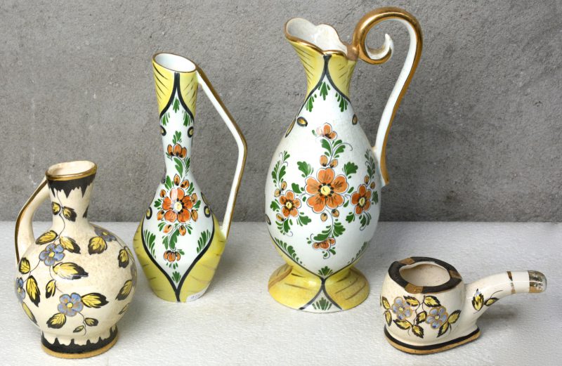 Een lot meerkleurig Gouda-aardewerk met glanzen glazuur, bestaande uit twee kannetjes met decor ‘Gisèle’ en een kannetje en een pijpvormige asbak met decor ‘Diana’.