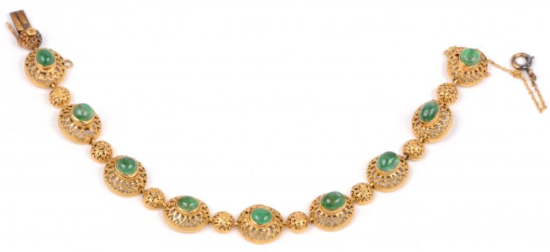 Een 18 karaats geel gouden schakelarmband bezet met negen smaragd cabochons met een gezamenlijk gewicht van ± 6,30 ct.