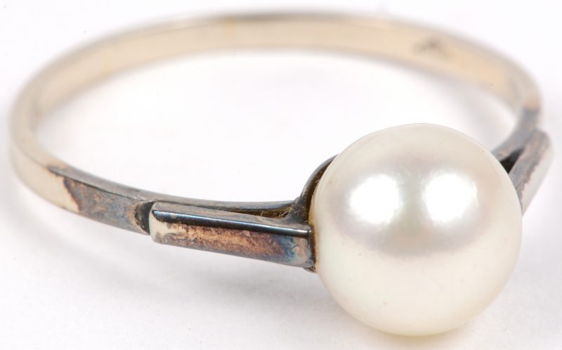 Een 18 karaats wit gouden ring bezet met een parel.