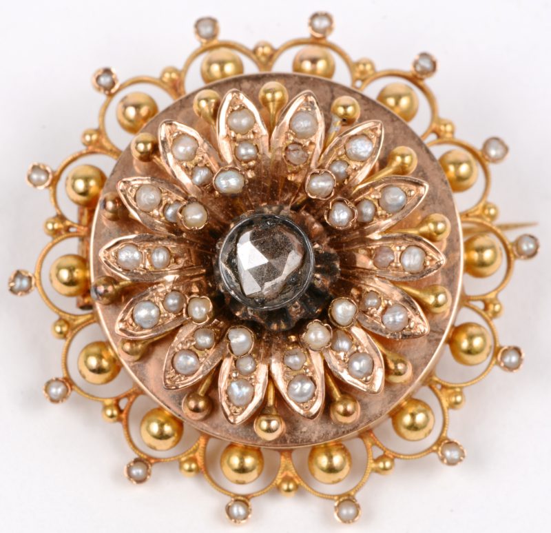Een 18 karaats geel gouden broche bezet met pareltjes en een centrale diamant oude slijp van ± 0,25 ct.