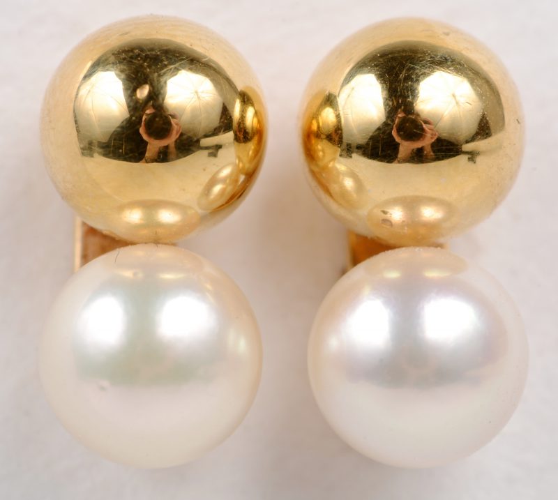 Een paar 18 karaats geel gouden oorbellen bezet met bolletjes goud en parels.