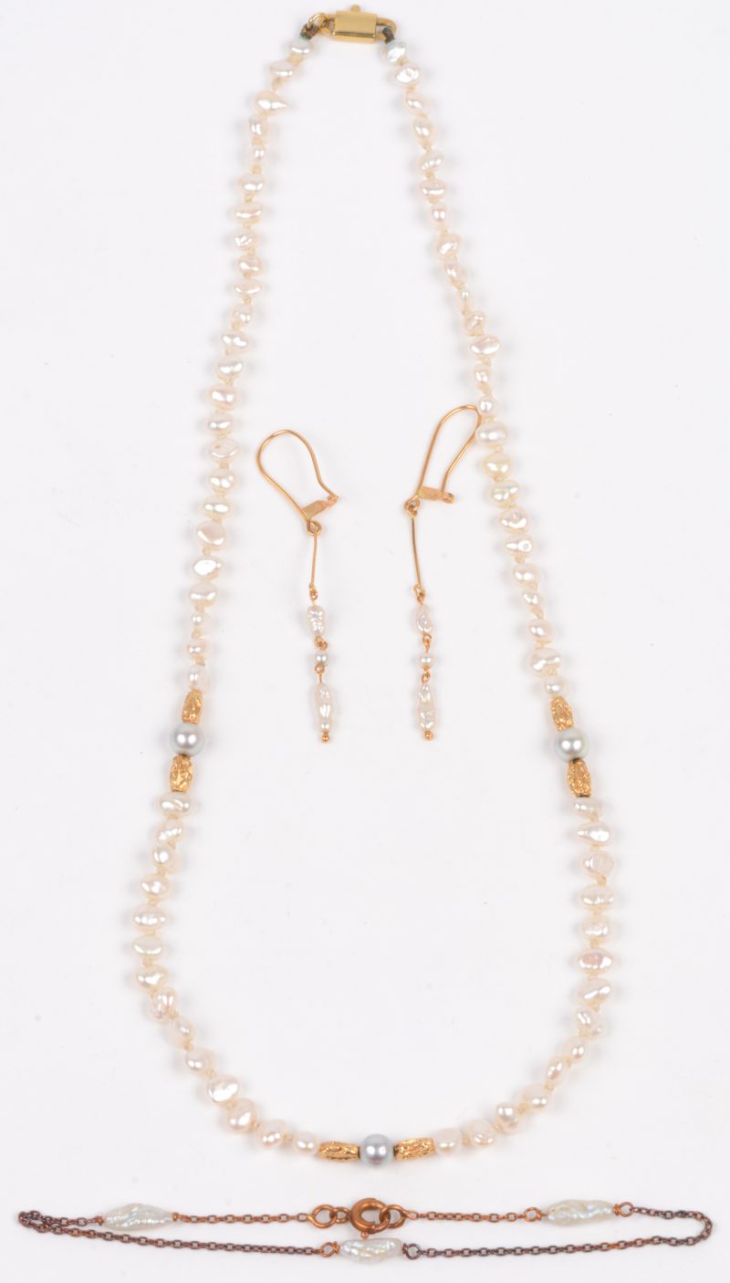 Een kleine halssnoer met bijpassende oorbellen en armband bezet met parels en 18 karaats geel gouden tussenstukken.
