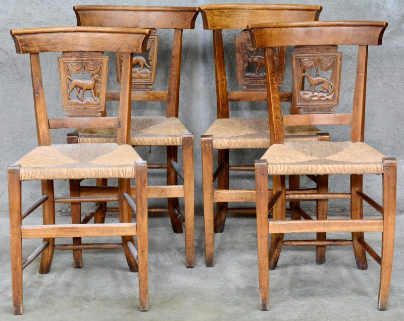 Een reeks van vier antieke gebeeldhouwde stoelen met een voorstelling van een wolf in de rug.