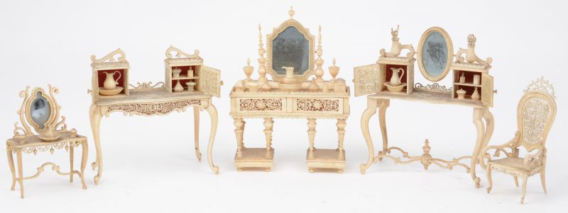 Een lot fijn gesculpteerde miniatuurmeubeltjes van ivoor, bestaande uit vier verschillende kaptafeltjes en een armstoel. Eén spiegeltje manco. XIXe eeuw.