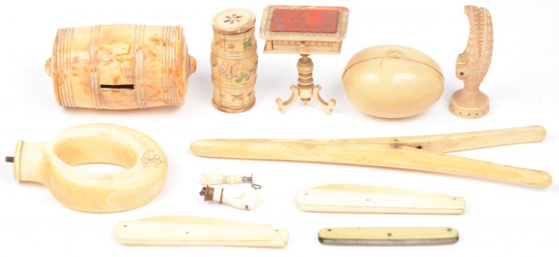 Een gevarieerd lot ivoor en been, waarbij een spaarpotje in de vorm van een ton, brievenopeners, stempels, een miniatuurmeubeltje, enz. XIXe eeuw.