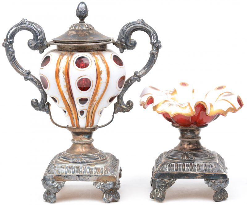 Twee XIXe eeuwse sierstukjes van zilver en witgepatineerd en verguld rood glas.