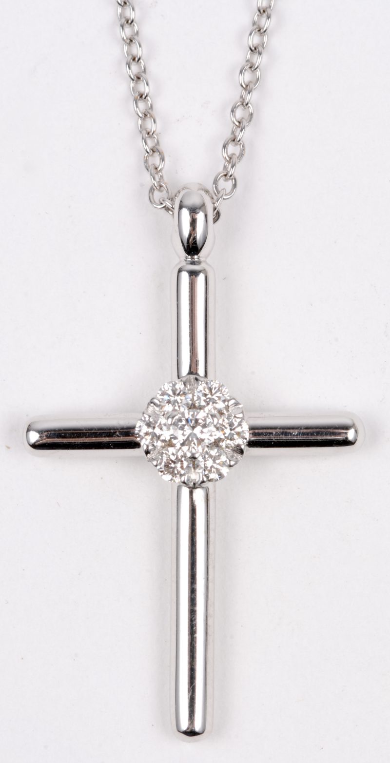 Een 18 karaats wit gouden ketting met hanger in de vorm van een kruisje bezet met briljanten met een gezamenlijk gewicht van ± 0,25 ct.