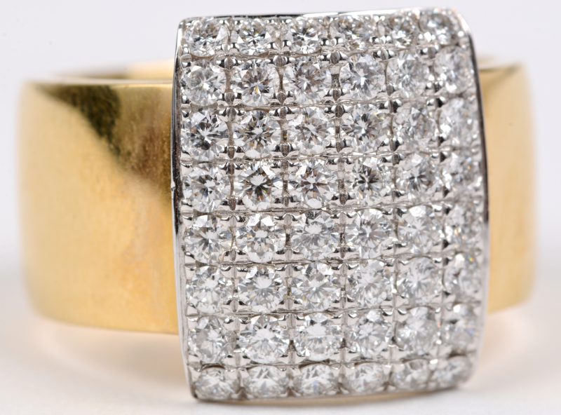 Een 18 karaats wit en geel gouden ring bezet met briljanten met een gezamenlijk gewicht van ± 1,22 ct.