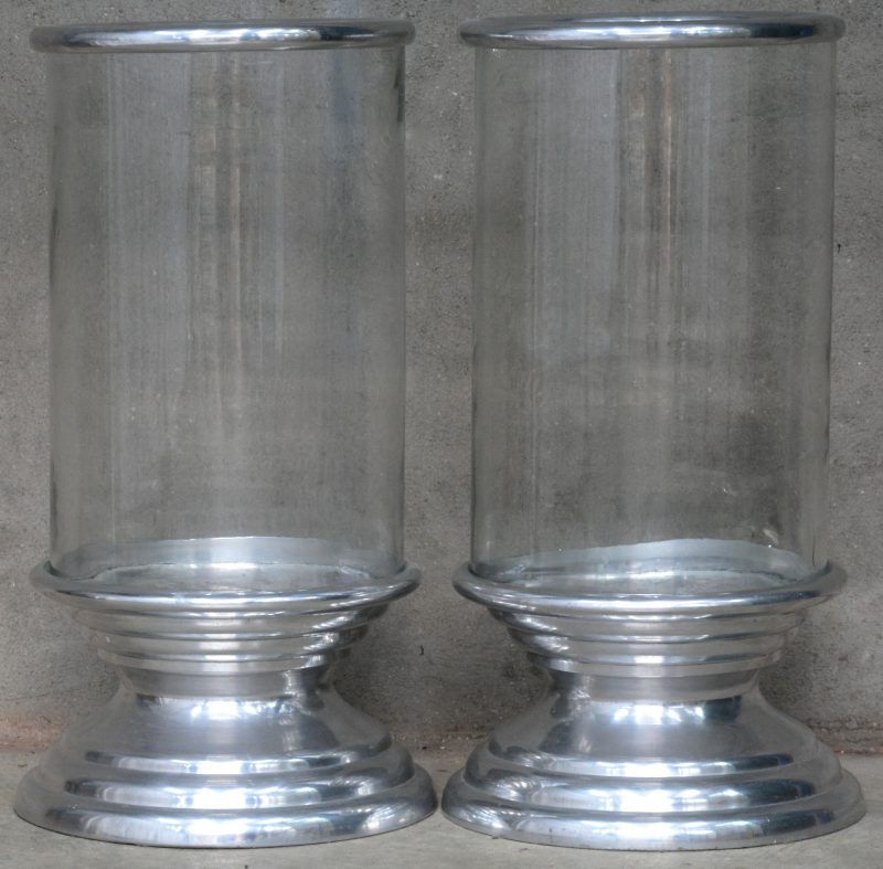 Twee grote glazen stormlampen met verzilverd metalen voet en montuur.