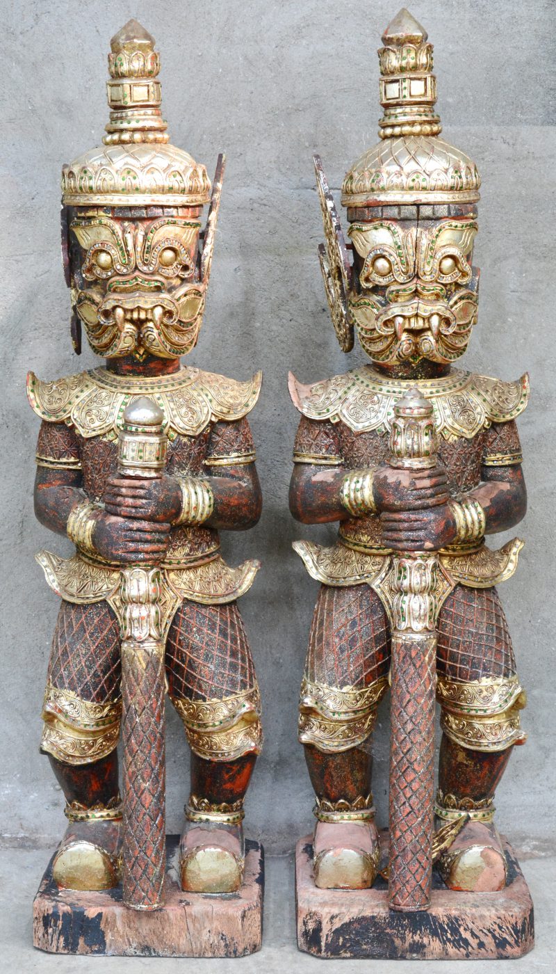 Een paar roodgepatineerde en vergulde Thaise tempelwachters. Eén versiering aan een oor manco.