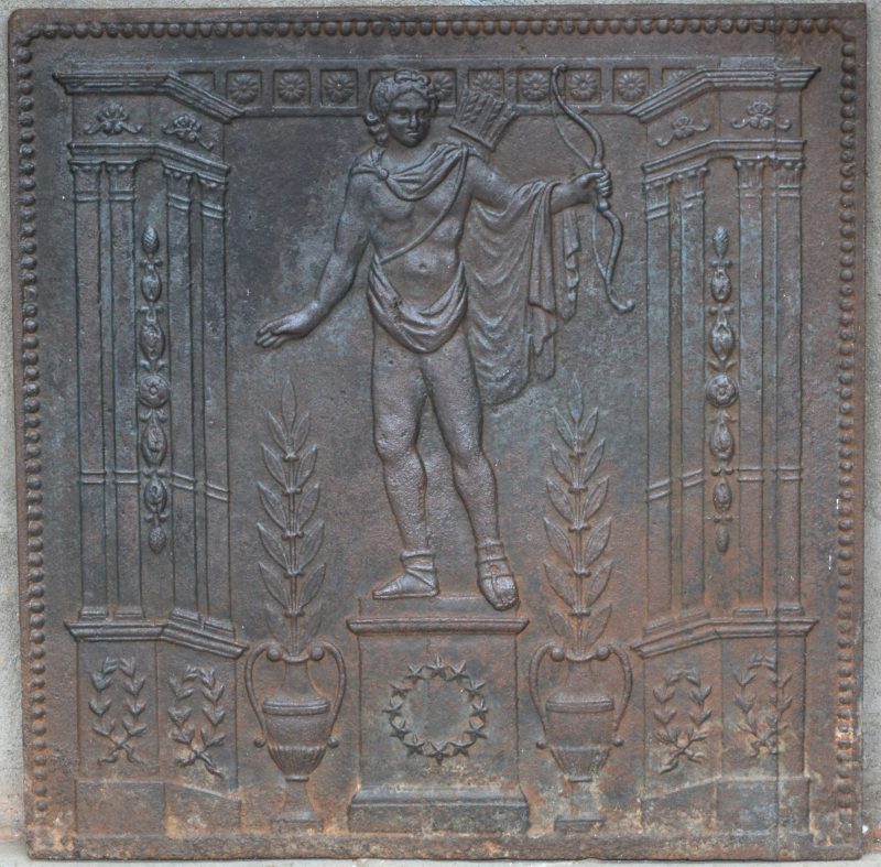 Een antieke gietijzeren haardplaat met een classicistische voorstelling van Apollo. Tijdperk Empire.