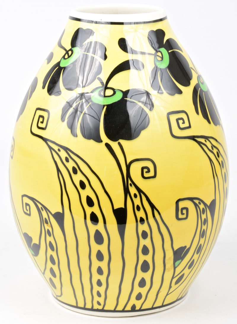 Een aardewerken vaas met een gestileerd bloemendecor in zwart en groen op gele fond. Onderaan gemerkt.