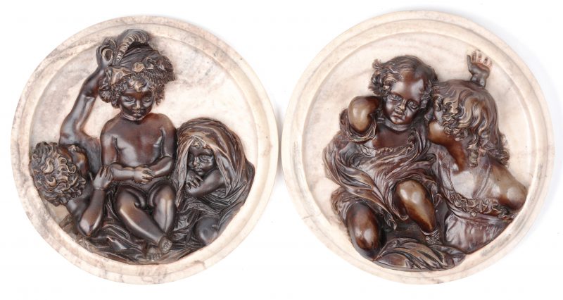 Een paar ronde marmeren hoogreliëfs met bruingepatineerde decors. Gesigneerd en gedateerd 1848.