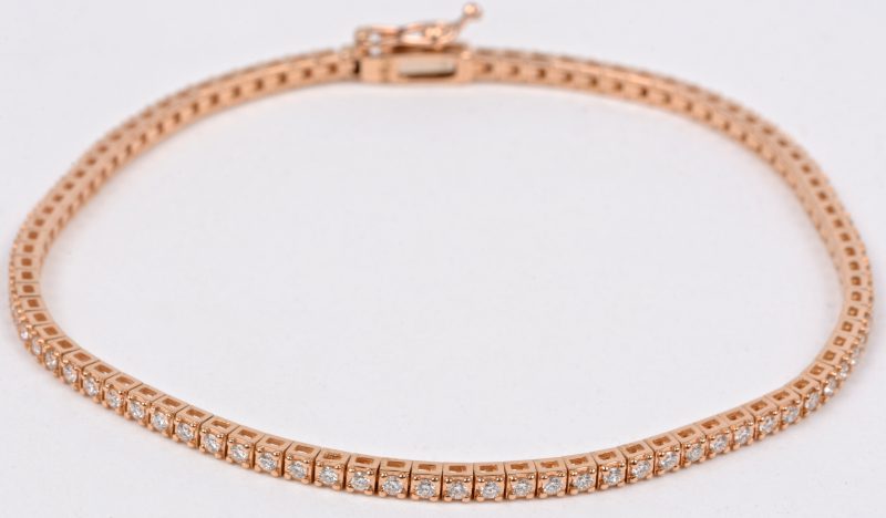 Een 18 karaats roze kleurige armband bezet met briljanten met een gezamenlijk gewicht van ± 1 ct.