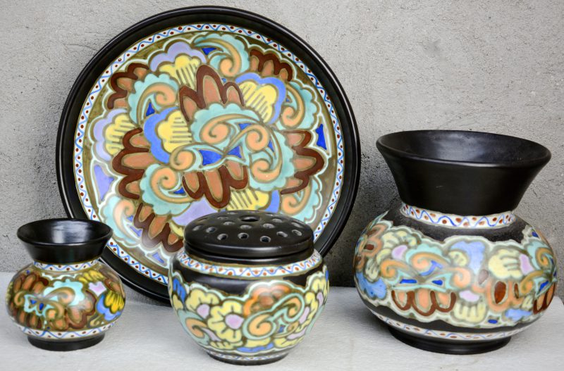 Een lot meerkleurig aardewerk, bestaande uit een grote en een kleine bolle vaas, een pique-fleurs en een diepe schotel. Allen gemerkt onderaan. Eerste helft XXe eeuw.