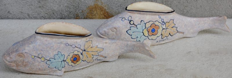 Een paar sierjardinières van Bergens aardewerk in de vorm van vissen, versierd met meerkleurige decors van bloemen en bladeren.