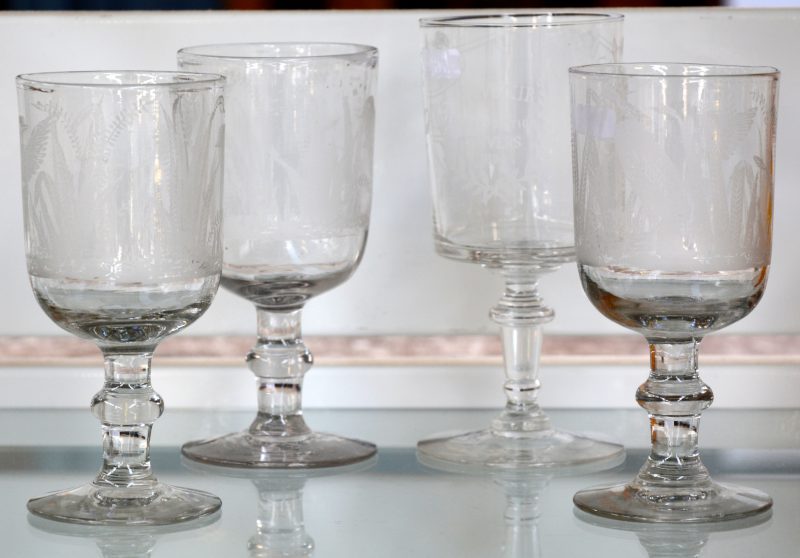 Een lot drie glazen van kleurloos glas met geslepen decors. We voegen er een vierde glas aan toe ter gelegenheid van de wereldtentoonstelling te Antwerpen in 1894.