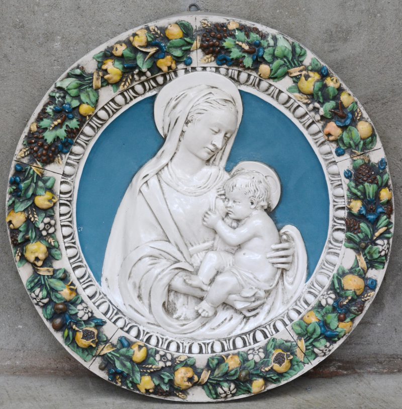 “Madonna met kind”. Een plaasteren plaquette met rondom gepolychromeerde motieven van fruit in reliëf.