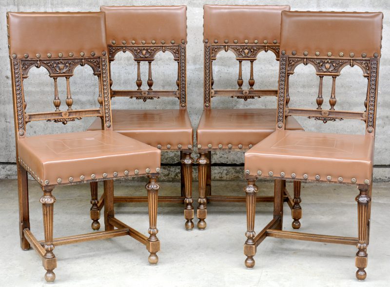Een reeks van vier stoelen met gerainureerde poten en bekleed met bruin leder.