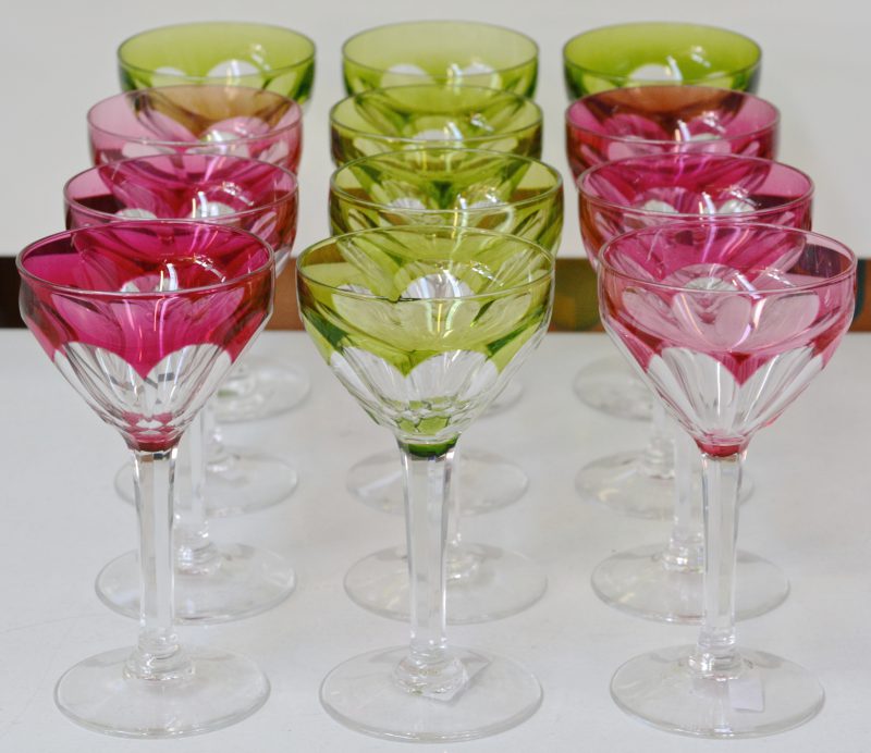 Een serie van twaalf geslepen glazen, waarvan zes roze en zes groene. Niet gemerkt.
