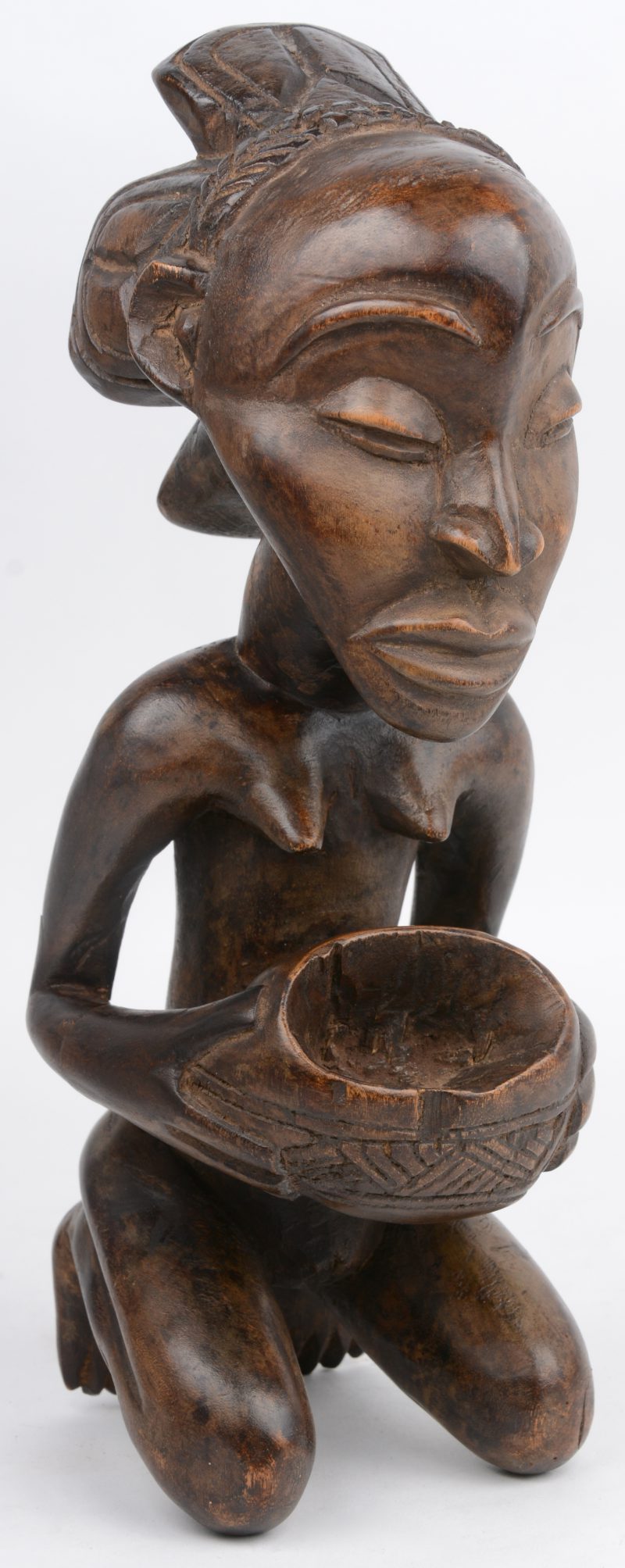 “Vrouw met kom”. Een gesculpteerd Afrikaans houten beeld. Luba, Congo.