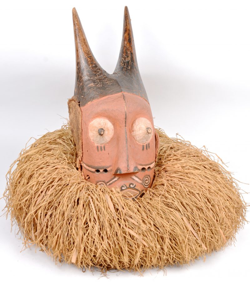 Een gepolychromeerd houten masker met kraag van stro.