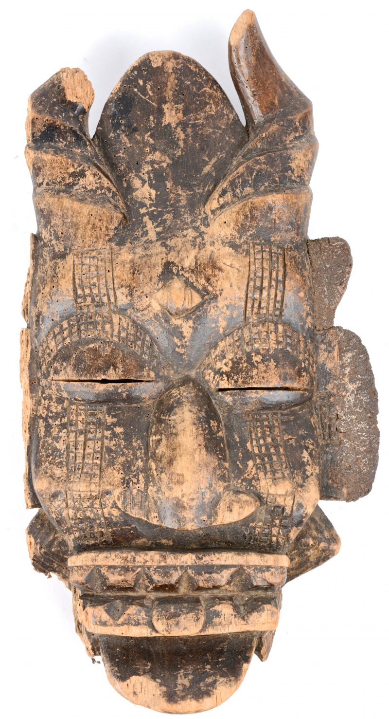 Een antiek Afrikaans houten masker op plexiglazen staander.