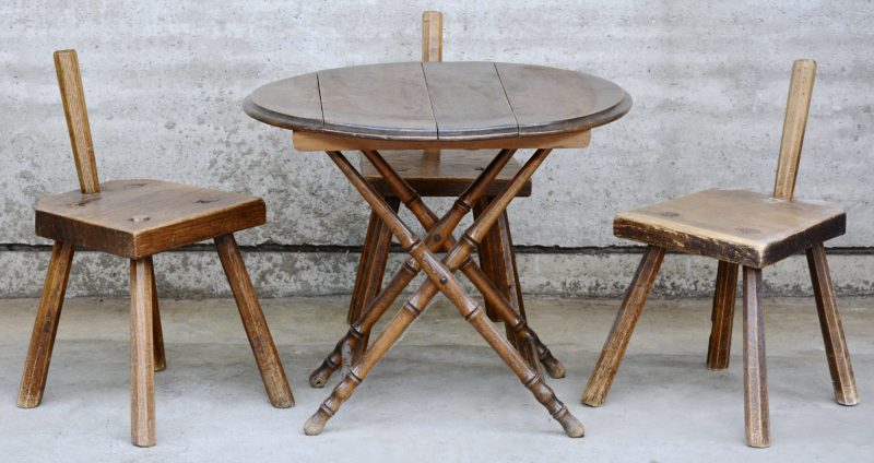Een opklapbaar rond tafeltje en drie kleine stoeltjes van eikenhout.