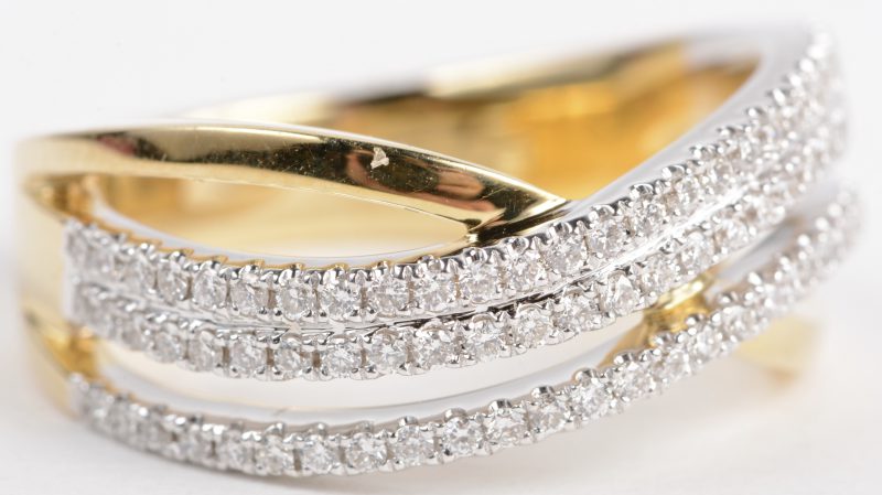 Een 18 karaats wit en geel gouden ring bezet met diamanten met een gezamenlijk gewicht van ± 0,46 ct.