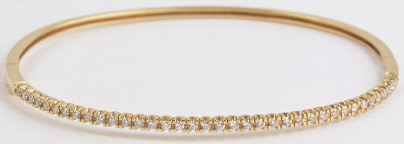 Een 18 karaats geel gouden slavenarmband bezet met diamanten met een gezamenlijk gewicht van ± 0,58 ct.
