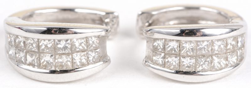 Een paar 18 karaats wit gouden oorbellen bezet met diamant princessen met een gezamenlijk gewicht van ± 0,82 ct.