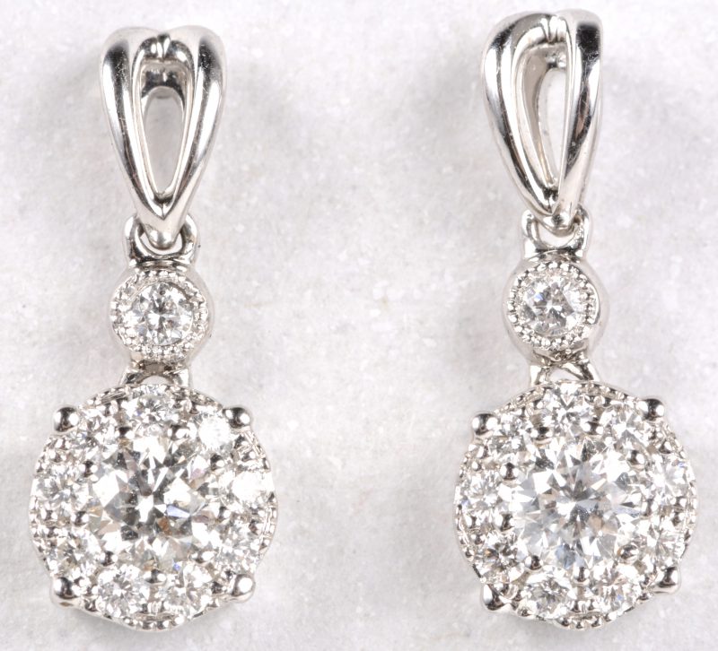 Een paar 18 karaats wit gouden oorbellen bezet met diamanten met een gezamenlijk gewicht van ± 0,48 ct.