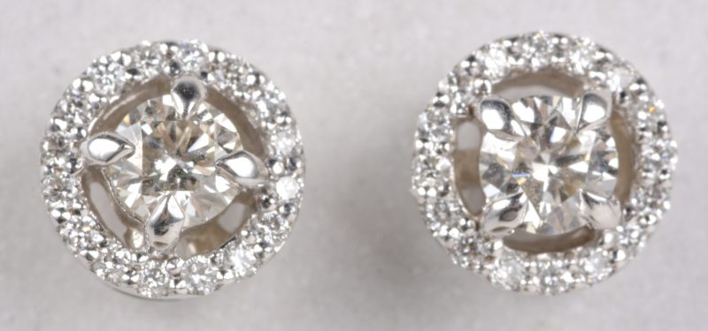 Een paar 18 karaats wit gouden oorbellen bezet met diamanten met een gezamenlijk gewicht van ± 0,72 ct.