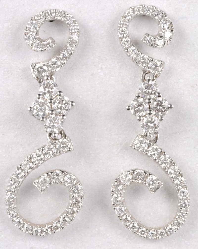 Een paar 18 karaats wit gouden oorbellen bezet diamanten met een gezamenlijk gewicht van ± 0,76 ct.