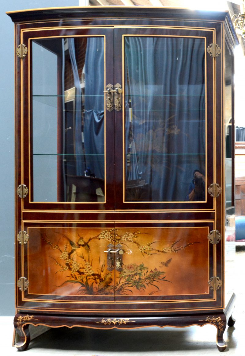 Een vitrine met twee gebogen paneeldeuren onder de gevitreerde deuren, versierd met Chinese decors van vogels en bloemen.
