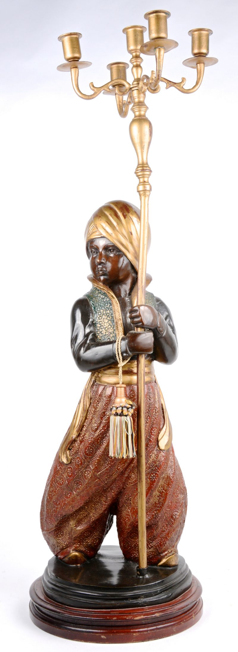 Een kandelaar, gedragen door een Oosterse dienaar van brons met meerkleurig patina.