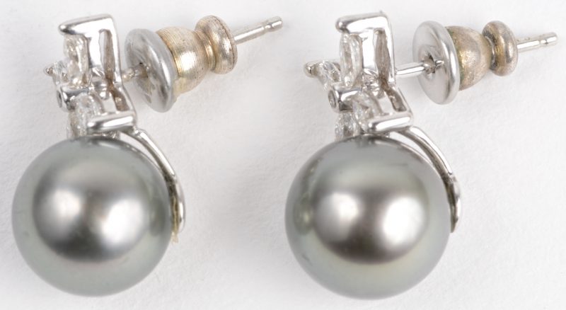Een paar 18 karaats wit gouden oorbellen bezet met diamant markiezen met een gezamenlijk gewicht van ± 0,40 ct. en twee grijze Tahiti parels.