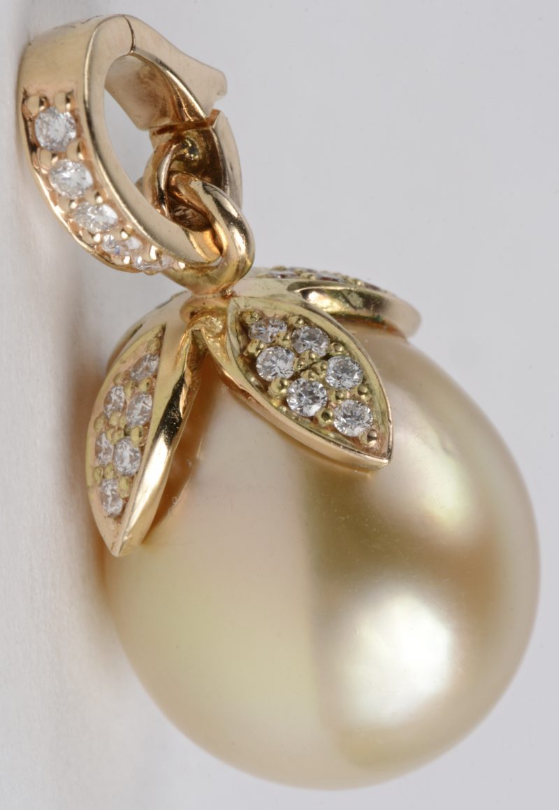 Een 18 karaats geel gouden hanger bezet met diamanten met een gezamenlijk gewicht van ± 0,30 ct. en een gele parel van 1,5 cm.