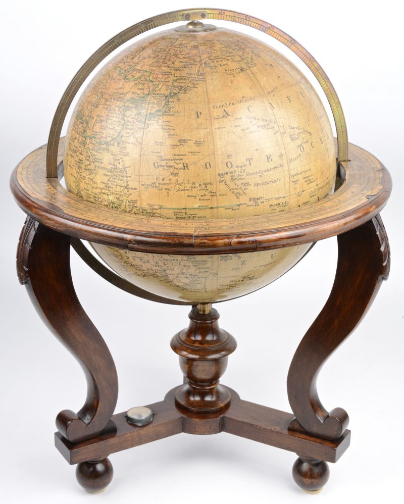 Een oude wereldbol in houten staander met ingewerkt kompas.