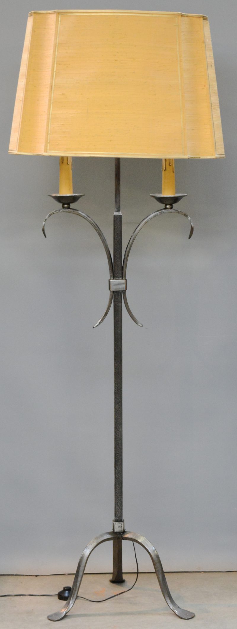 Een smeedijzeren dubbele kandelaar, gemonteerd als staande lamp.