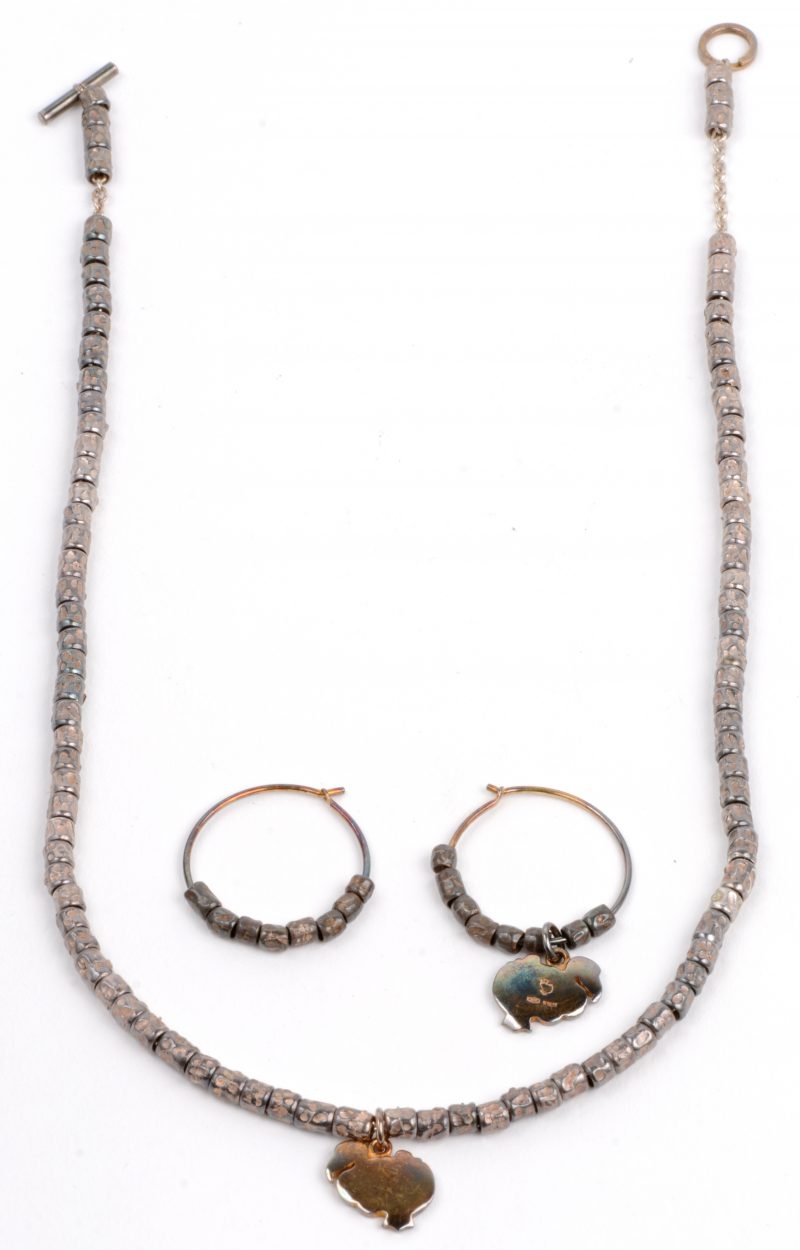 Een halssnoer met bijpassende oorbellen van zilver met twee hangers van 18 karaats geel goud.