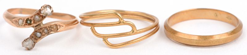 Drie verschillende 18 karaats geel gouden ringen waarvan één bezet met pareltjes en diamant oude slijp.