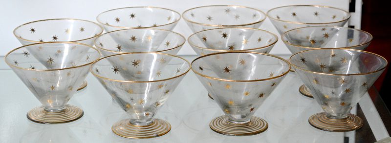 Een lot glas en kristal, bestaande uit elf coupes met vergulde decors en elf kleurloze coupes, waarbij een reeks van zeven en twee paar.
