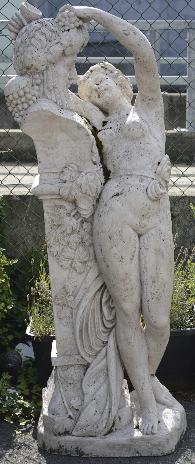 “Vrouw bij een fontein in de vorm van Bacchus”. Een marmeren tuinbeeld.