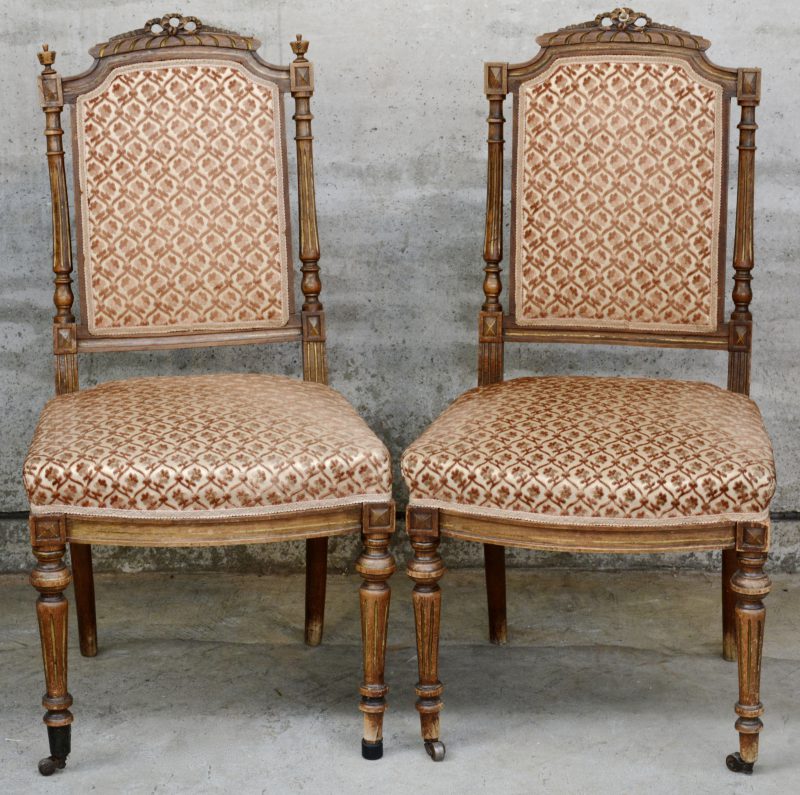 Een paar gebeeldhouwde stoelen in Lodewijk XVI-stijl.