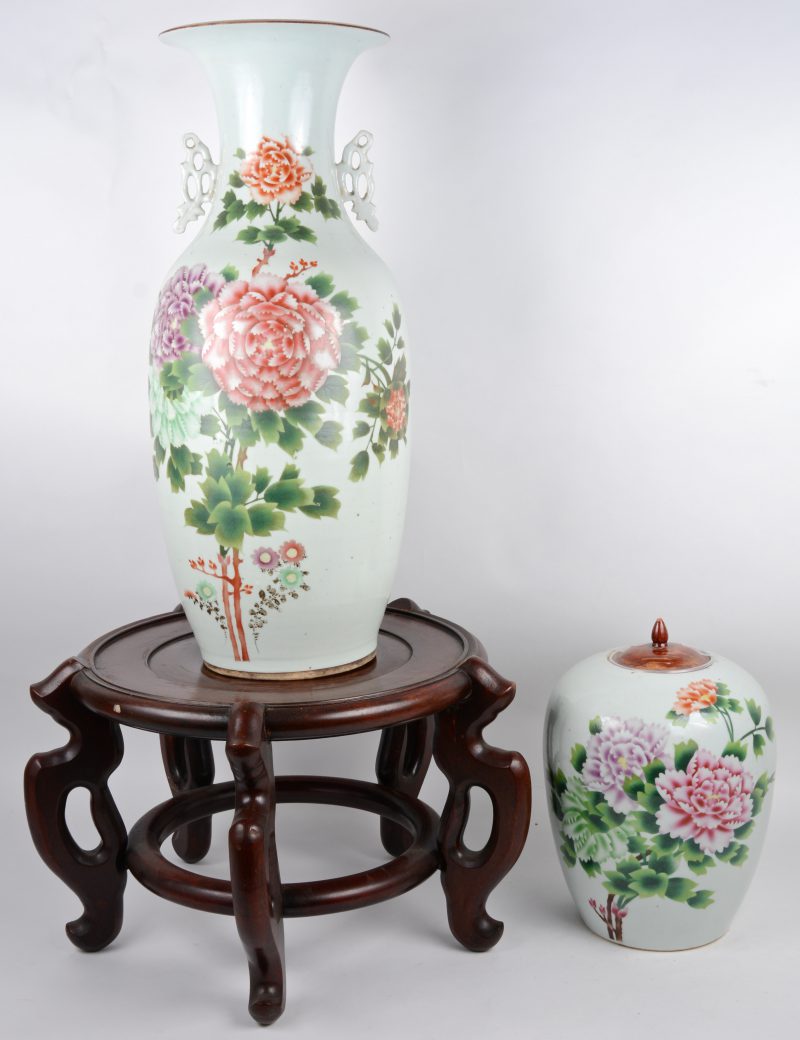 Een balustervaas en een dekselpot van Chinees porselein, versierd met een meerkleurig decor van pioenen. Omstreeks 1900. De balustervaas op houten sokkel,