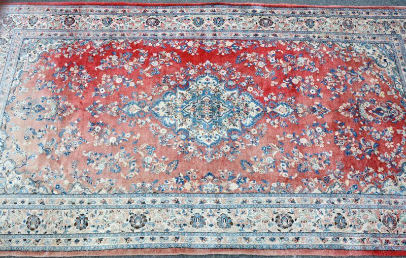 Perzisch tapijt van wol met medaillon. Handgeknoopt. Deels verschenen.