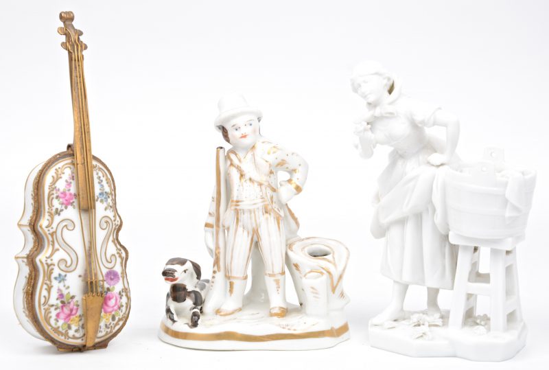 Een lot porselein, bestaande uit een XIXe eeuwse inktpot met een jager met hond van Brussels porselein, een vioolvormig doosje van Meissenporselein en een wasvrouw. Het laatste met kleine beschadiging aan het handje.