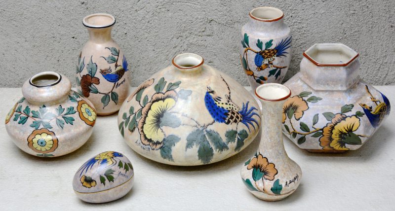 Een lot meerkleurig aardewerk met meerkleurige decors van Antoine Dubois, bestaande uit zes verschillende vazen en een eivormig dekseldoosje.