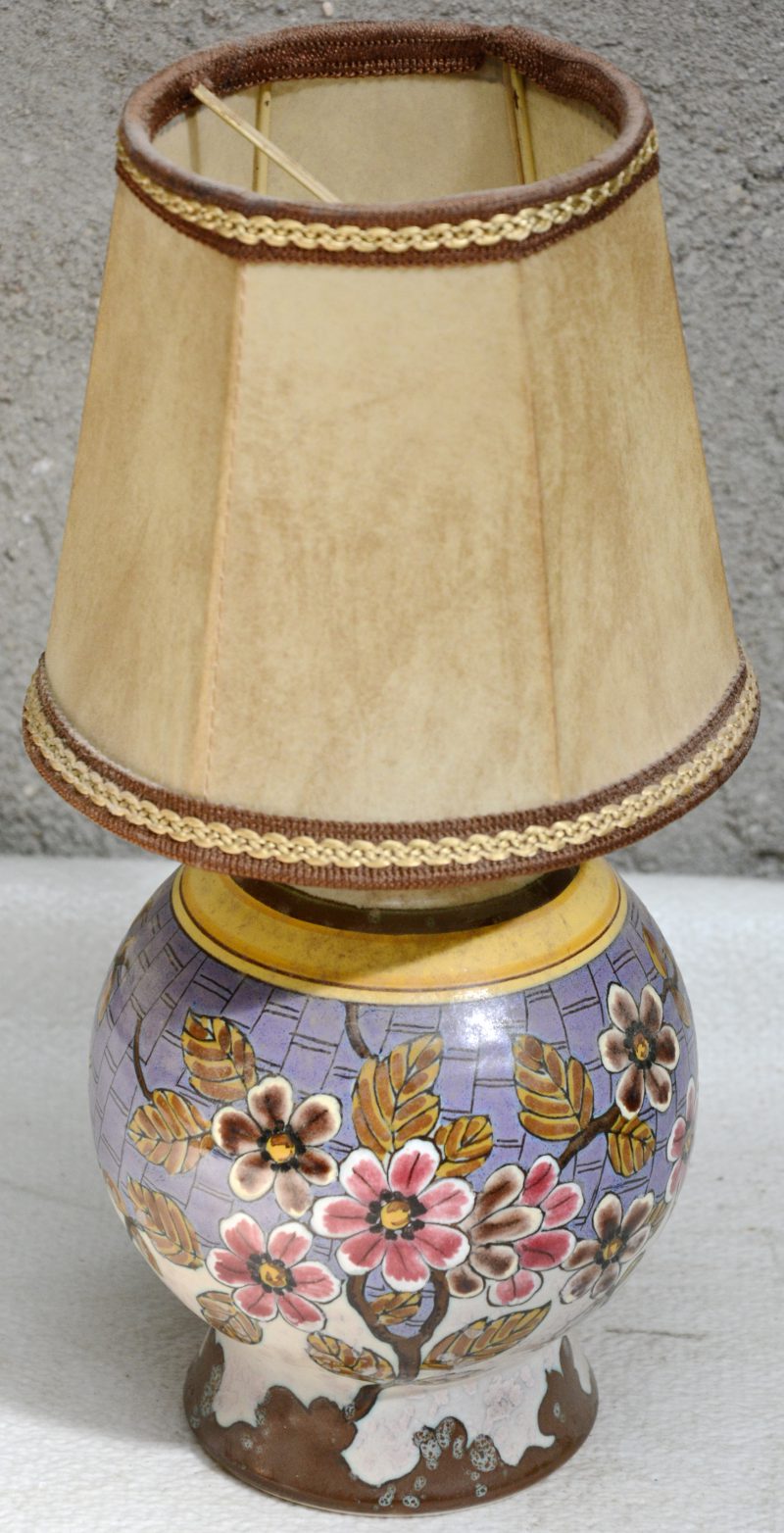Een bolle lampvoet van Gouds plateel, versierd met een meerkleurig bloemendecor. Onderaan gemerkt.